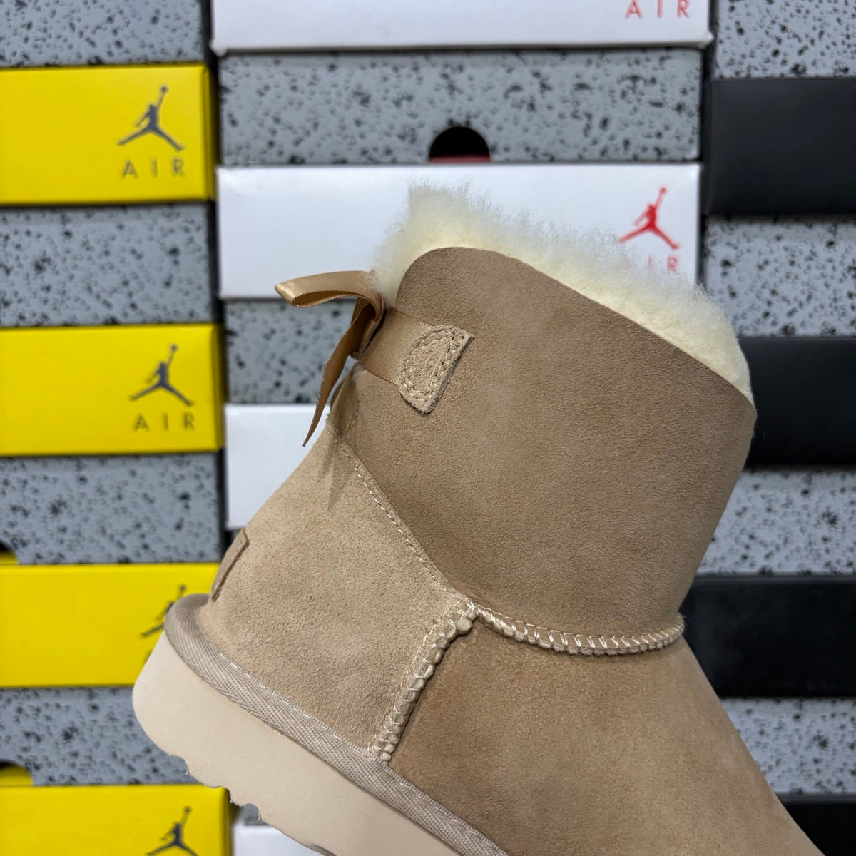 UGG Mini Bailey Bow Ankle Boot – Suede Boot with Cream Shearling Lining, Satin Bow Detail & Sand Sugar Sole in Sand